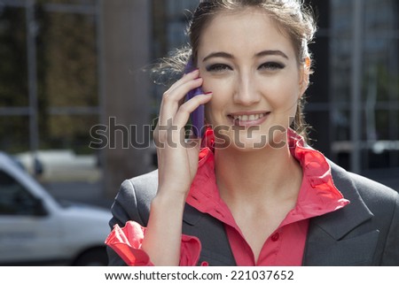 Portrait of business wife with a mobile phone on street.