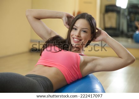 Young woman does crunches on a balance ball