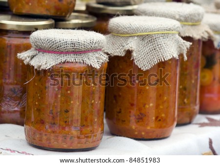 ajvar - traditional Serbian food, packaged in bottles, standing on the table
