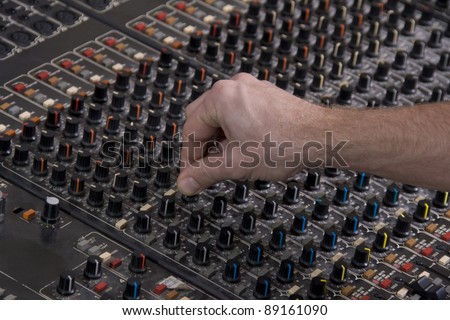 Large Music Mixer desk in the music studio with the operator\'s hand