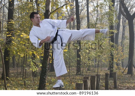 Man wearing  (Karate uniform) and black belt shown in a kick