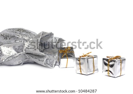 The gifts which are dropping out of a silver bag on a white background