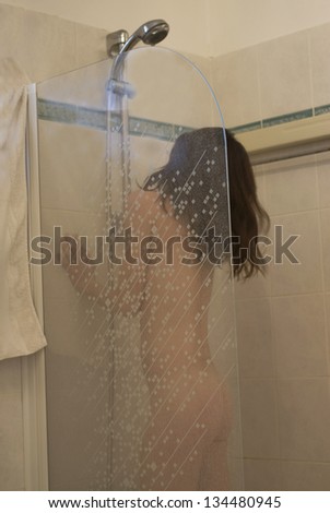 young woman washing her body in a shower