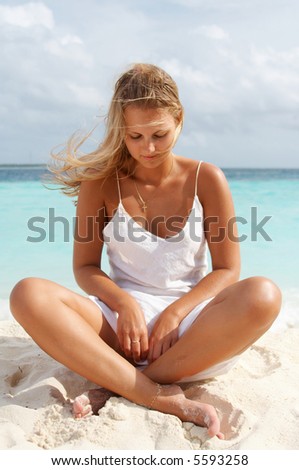 Woman in meditation. Maldives. She has perfect bronzed body.