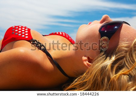 Young girl in red bikini is taking sun bath