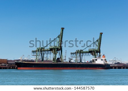 Large vessel unloading its iron ore cargo