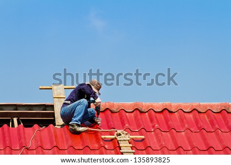Worker repairing roof