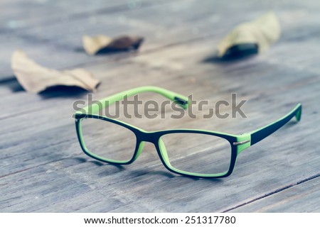 Sight glasses and dried leafs on bamboo floor in vintage