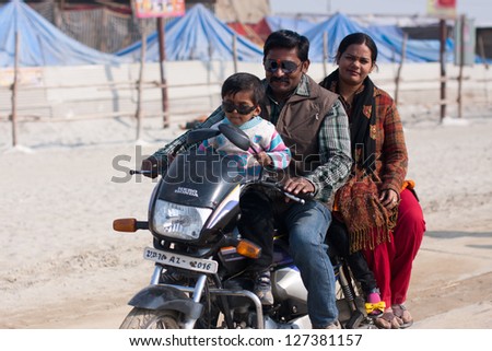 ALLAHABAD, INDIA - JAN 28: Indian family rides a motorbike on a holiday during hindu festival Kumbh Mela on January 28, 2013 in Allahabad, India. Kumbh Mela is the largest single gathering of humanity