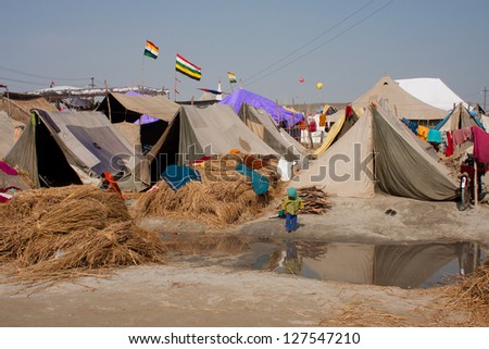 ALLAHABAD, INDIA - JAN 26: Unidentified indian child walk against the tents of the biggest festival in the world - Kumbh Mela on January 27 2013 in Allahabad India. The festival is held every 12 years