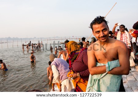 SANGAM, INDIA - JAN 27: Young indian man smiling after bathe in the confluence of Ganges and Yamuna during the Kumbh Mela on January 27, 2013 in Allahabad, India. In 2013, Mela take 130 mill. people