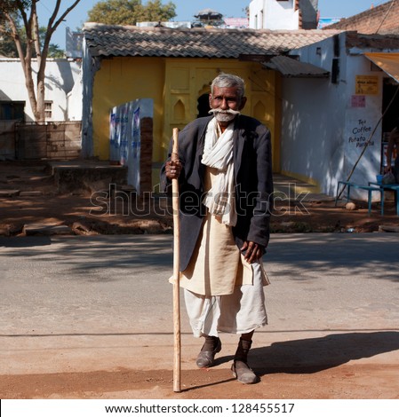 ORCHHA, INDIA - DEC 20: Poor elderly man walk the street at the sunny day on December 20 2012, in Orchha, India.  60-plus age group in India will increase to 100 million people in 2013.
