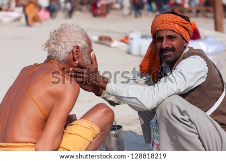 ALLAHABAD, INDIA - JAN 27: Indian masseur doing massage of the face to pilgrim on the biggest festival Kumbh Mela on January 27, 2013 in Allahabad, India. It is held every 12 years on banks of Sangam