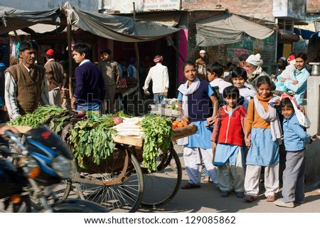 LUCKNOW, INDIA - DEC 19: unidentified children have fun on the crowed indian street at the sunny day on December 19, 2012 in Lucknow, India.  Lucknow in Uttar Pradesh state has population of 4,588,455