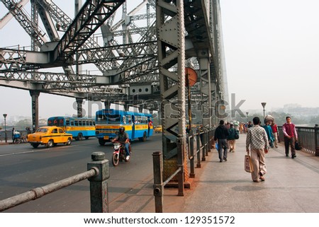 KOLKATA, INDIA - JAN 18: People and buses moves on Howrah bridge on the Howrah bridge on January 18 2013 in Kolkata, India. Howra bridge bears the day traffic of 100,000 vehicles & 150,000 pedestrians