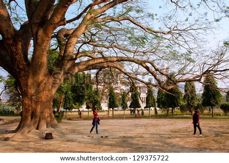 KOLKATA, INDIA - JAN 16: Two young woman play badminton in the shadow garden near the Victoria Memorial on January 16, 2013 in Kolkata. The Garden of the Memorial was designed on area of 0.26 sq.km