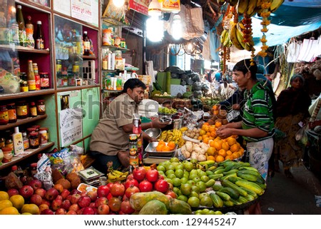 KOLKATA, INDIA - JANUARY 16: Customer buys fruit in the colorful city market on January 16, 2012 in Kolkata India. Only 0.81% of the Kolkata\'s workforce employed in the primary sector (agriculture)
