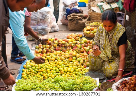 KOLKATA, INDIA - JAN 13: Asian woman sell fruits and vegetables on the crowd market street on January 13, 2012 in Kolkata India. Only 0.81% of the Kolkata\'s workforce employed in agriculture sector