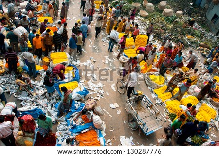 KOLKATA, INDIA - JAN 13: Bicycle rickshaw goes through crowded Mullik Ghat Flower Market on January 13, 2013. The market is more than 125 years old. More than 2000 sellers work in the market every day