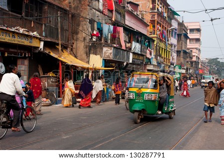 KOLKATA, INDIA - JAN 11: Private auto rickshaw three-weeler tuk-tuk taxi drives down the street on January 11, 2013 in Kolkata. Indian three-wheelers have the design of the Piaggio Ape C, from 1948