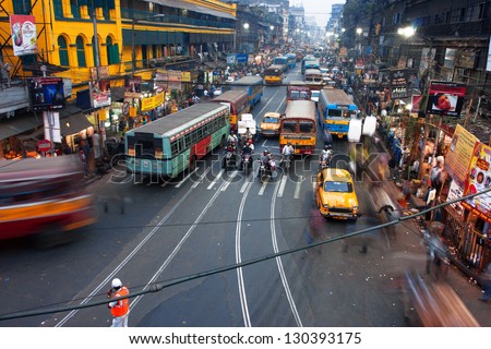 KOLKATA, INDIA - JAN 17: People and cars blurred in motion on the busy street of the asian metropolis on January 17, 2013 in Kolkata, India. Kolkata has a density of 814.80 vehicles per km road length