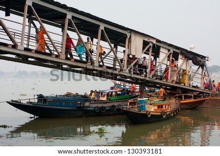 KOLKATA, INDIA - JAN 15: River ferry passengers go ashore at the Dakshineswar dock on January 15 2013. Third biggest indian city, Kolkata with its suburbs, is home to approximately 14.1 million people