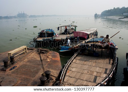 KOLKATA, INDIA - JAN 15: Boat drivers wait for the passengers at the old river dock on January 15, 2013. Third biggest indian city Kolkata with its suburbs is home to approximately 14.1 million people