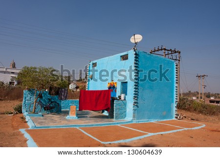 ORCHHA, INDIA - DEC 23: Modern village house of blue color with satellite antenna on the roof on December 23 2012 in Orchha, India. Town Orchha in Madhya Pradesh state has a population of 10000