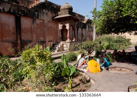 ORCHHA, INDIA - DEC 21: Indian family have rest in the old garden at the bright day on December 21, 2012 in Orchha, Madhya Pradesh, India. Orchha had a population of 10000. Females constitute 47%