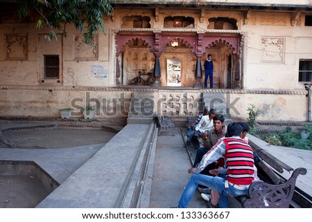 ORCHHA, INDIA - DEC 21: Group of the Indian teenagers meet in the old city garden on December 21, 2012 in Orchha, Madhya Pradesh, India. Orchha had a population of 10000. Males constitute 53%
