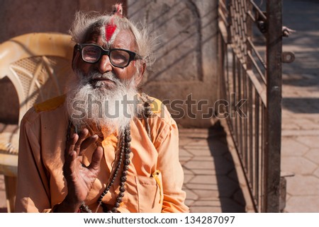ORCHHA, INDIA - DEC 20: Senior hindu man with vintage glasses poses on the street on December 20 2012 in Orchha, Madhya Pradesh, India. Orchha had a population of 10000. Males constitute 53%