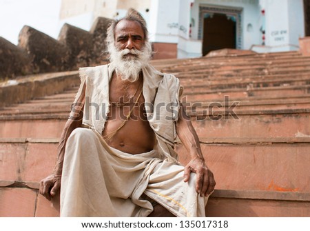 CHITRAKOOT, INDIA - DEC 29: Old hindu man sits on the steps outdoor at morning on December 29 2012 in Chitrakoot, India. Population of Chitrakoot is 22,294. By the legend, god Rama lived here 11 years
