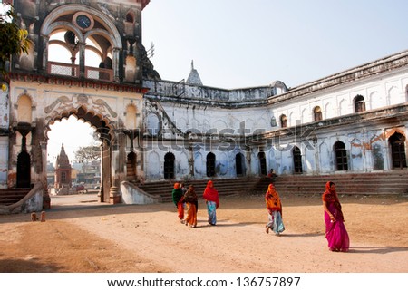 AYODHYA, INDIA - JAN 28: Women in traditional indian dresses walking past gateway of asian city on January 27, 2013 in Ayodhya, India. Ayodhya, with a population of 49,593, is birthplace of Lord Rama
