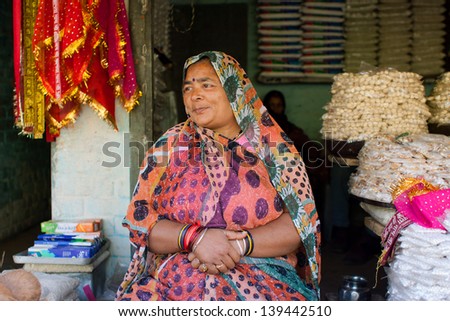 CHITRAKOOT, INDIA - DEC 30: Indian woman in colorful sari sitting at the counter of a small street on December 30, 2012 in Chitrakoot, India. Population of Chitrakoot is 22,294. Females constitute 43%
