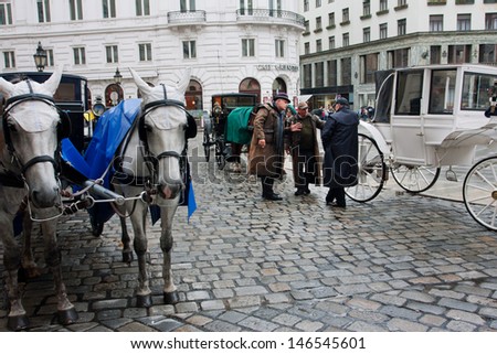 VIENNA, AUSTRIA - JUNE 4: Fiaker coachmen in a vintage dress have emotional conversation near the horse-drawn carts on June 4, 2013 in Vienna. Vienna attracts about five million tourists a year