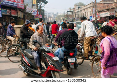 VARANASI, INDIA - JANUARY 1: Motorcycle drivers, cyclists and pedestrians move on the busy crowded street at the morning on January 1, 2013. Varanasi urban agglomeration had a population of 1,435,113