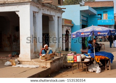 VARANASI, INDIA - JAN 3: Asian trader reads the morning newspaper in front of his place of sale on January 3, 2013 in Varanasi, India. The literacy rate in the Varanasi urban agglomeration is 77%