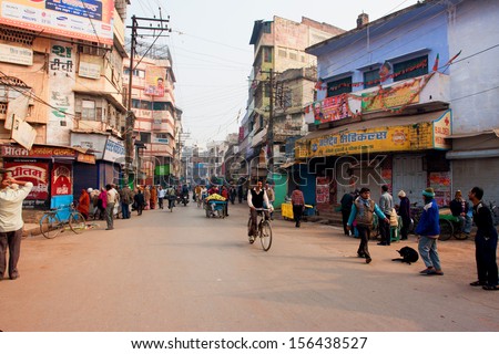 VARANASI, INDIA - JANUARY 2: People movement with the cycles on the busy indian street with the old buildings at evening on January 2, 2013.Varanasi urban agglomeration had a population of 1,435,113