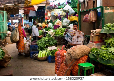 KOLKATA, INDIA - JANUARY 10: Vegetable seller reads a newspaper and waits for the customers on the old city market on January 10, 2012 in Calcutta. 0.81% of Kolkata\'s workforce employed in agriculture