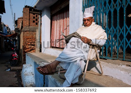 BIHAR, INDIA - JAN 9: Elderly asian man reads a newspaper outdoor at the evening on Januari 9, 2013 in Gaya, India. Bihar total literacy is 62,8%. Ancient Bihar was a center of learning and culture.