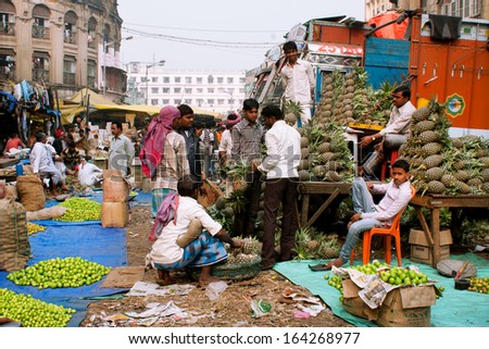 KOLKATA, INDIA - JAN 13: Pineapple sellers meeting on the street market on January 13, 2012 in Calcutta. Only 0.81% of the Kolkata\'s workforce employed in the primary sector (agriculture)