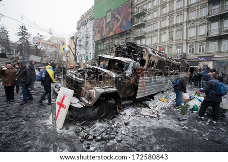 Kyiv, Ukraine - Jan 21: People Walk Around The Barricades With Burned Out Military Cars On The Snow Street During Anti-Government Protest On January 21, 2014, In Kiev, Ukraine.