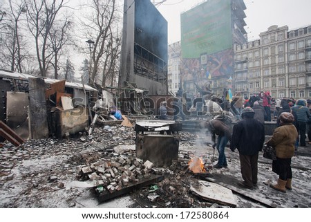 KYIV, UKRAINE - JAN 21: People heating by the fire near the barricades after fights with police on the broken pavement street during anti-government protest on January 21, 2014, in Kiev, Ukraine.