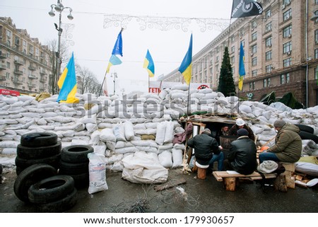 KIEV, UKRAINE - DEC 12: People sit and guard the barricades of white bags during anti-government Euromaidan protest on December 12 2013. More than 800,000 protesters participated in Kiev\'s Euromaidan