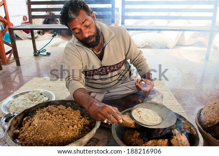 CHITRAKOOT, INDIA - DEC 28: Asian man cook national bread on low heat from dry manureon on December 28, 2012. Population of Chitrakoot is 22,294. By the legend, Lord Rama lived here