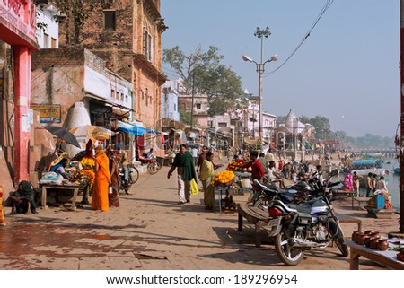 CHITRAKOOT, INDIA - DEC 29: People walk on the indian street with outdoor trading stalls with flowers on December 29, 2012. Population of Chitrakoot is 22,294. Mandakini River flows through the city.
