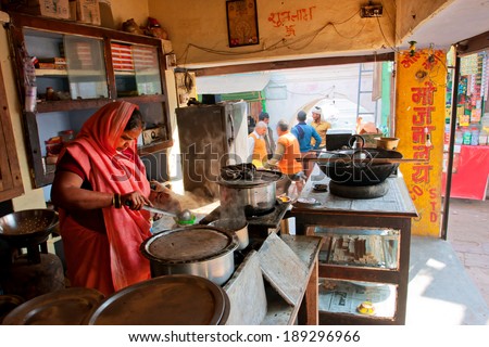 CHITRAKOOT, INDIA - DEC 28: Woman woman cooks food in an outdoor cafe on the crowded indian street on December 28, 2012. Population of Chitrakoot is 22,294. By the legend, Lord Rama lived here