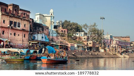 MADHYA PRADESH, INDIA - DEC 28: Old indian city buildings over the river with colorful boats for the tourists on December 28, 2012 in Chitracoot. Population of Chitrakoot is 22,294 people.