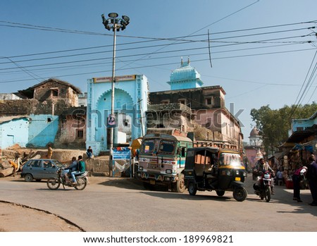 MADHYA PRADESH, INDIA - DEC 27: Street traffic with rickshaw, cars and a bike in old indian city with historical buildings on December 27, 2012 in Chitracoot. Population of Chitrakoot is 22,294 people