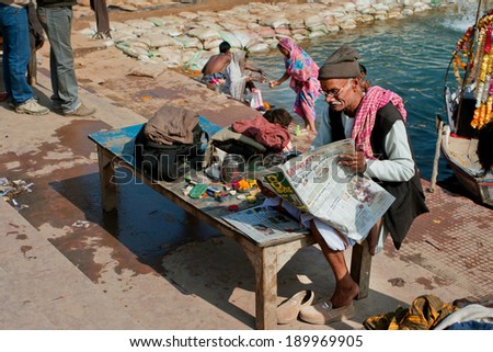 MADHYA PRADESH, INDIA - DEC 27: Lonely man read a newspaper at the riverbank of old indian city on December 27, 2012 in Chitracoot. Population of Chitrakoot is 22,294 people.
